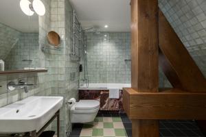 a bathroom with a sink and a toilet and a tub at Carillon Aparthotel - Keystone Collection, opened December 2025 in Riga