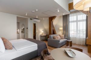 a hotel room with a bed and a couch and a table at Carillon Aparthotel - Keystone Collection, opened December 2025 in Riga +46 photos