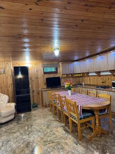 a kitchen with a table and chairs and a kitchen with a stove at Бистриця in Chynadiyovo