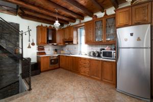 a kitchen with wooden cabinets and a white refrigerator at villa eirini in Kourélion