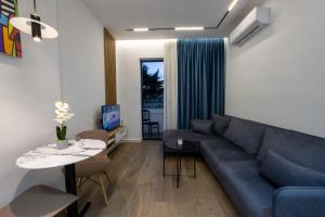 a living room with a blue couch and a table at Bliss Modern Retreat in Tirana