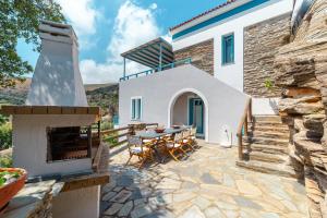 an outdoor patio with a table and a fireplace at villa eirini in Kourélion