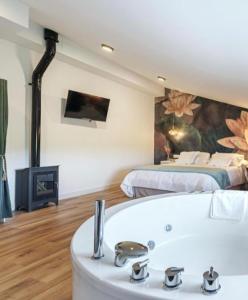 ein Badezimmer mit Badewanne und ein Schlafzimmer mit Bett in der Unterkunft DUO SOMNIA, suites con jacuzzi y chimenea, only adults in Barbatona