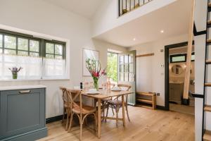 a kitchen and dining room with a wooden table and chairs at The Old Workshop, Combrook in Combrook