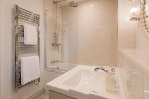 a white bathroom with a sink and a shower at The Old Workshop, Combrook in Combrook +21 photos