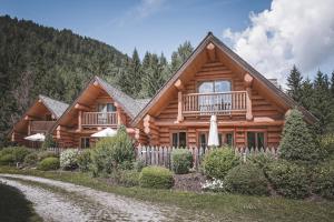a log cabin with a porch and a balcony at Nancy's Holiday Homes Dolomites in Rasùn di Sotto