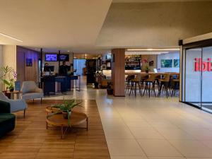 a lobby of a hotel with tables and chairs at ibis Sao Luis in São Luís