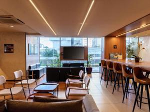 a lobby with a bar and chairs and a television at ibis Sao Luis in São Luís
