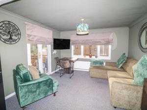 a living room with a couch and chairs and a table at The Nest Lodge 55 in Grantham