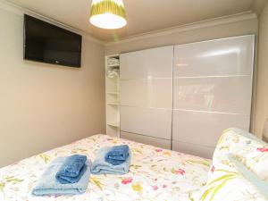 a bedroom with a bed with towels on it at The Nest Lodge 55 in Grantham