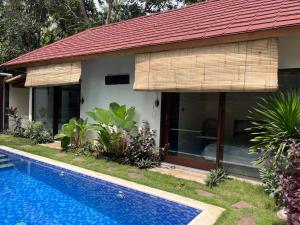 a house with a swimming pool in front of it at Villa Semoga in Tanjung