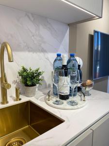 a kitchen counter with bottles of water and wine glasses at Apartament DeLuxe Zamość Prywatny parking podziemny in Zamość +41 photos