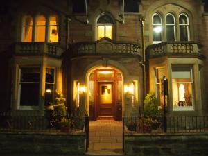a house with a wooden door at night at Craignay Guest House in Inverness