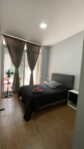 a bedroom with a bed and a large window at PB-Súper dpto Morón centro in Morón