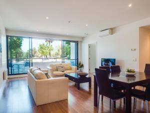a living room with a couch and a table at Waterfront (Yarra St) by Gold Star Stays in Geelong