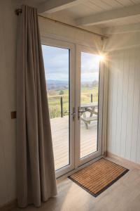 a sliding glass door with a view of a deck at Luxury Shepherds Hut with Hot Tub Valley Views in Scarborough
