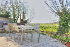 a wooden table with four chairs on a patio at The River Cottage in Middelkerke