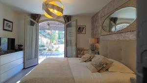 a bedroom with a large bed and a large mirror at Le Mas des Roches à Velaux in Velaux +98 photos
