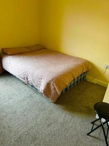 a small bed in a corner of a room at Babo room in Farnworth