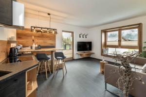 a kitchen and living room with a table and chairs at HOLZLODGE APARTMENTS - Alpine Living in Radstadt - Salzburger Sportwelt in Radstadt