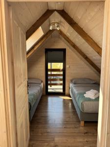 a attic room with two beds and a door at Gołąbek Stronie Śląskie in Stronie Śląskie
