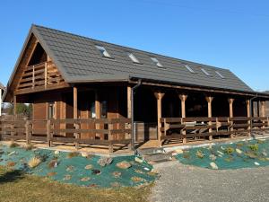 a large wooden building with a black roof at Gołąbek Stronie Śląskie in Stronie Śląskie