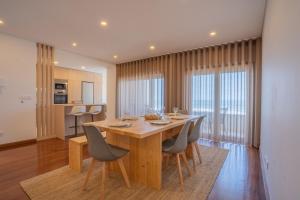 a kitchen and dining room with a wooden table and chairs at Granja Beach Front in São Félix da Marinha +2 photos