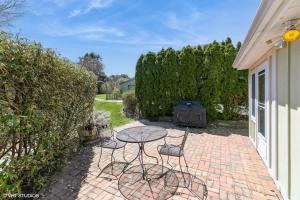 a patio with a table and chairs and a grill at Seabreeze #3 - Cozy cottage by the beach in Hampton Bays