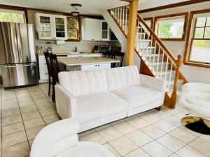a living room with a white couch and a kitchen at Seabreeze #3 - Cozy cottage by the beach in Hampton Bays