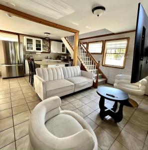 a living room with white furniture and a kitchen at Seabreeze #3 - Cozy cottage by the beach in Hampton Bays