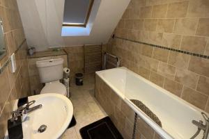 a bathroom with a sink and a tub and a toilet at Guildford Court Apartment Colchester in Colchester