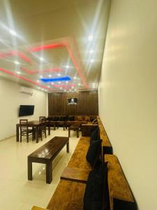 a room with benches and tables and a tv at Hotel Divine Light Monaragala in Monaragala