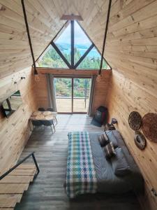 ein Schlafzimmer in einer Blockhütte mit einem großen Fenster in der Unterkunft Tranquilo Austral in Puerto Tranquilo