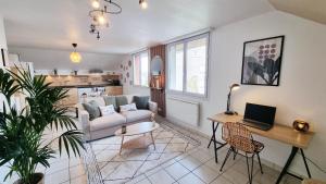 a living room with a couch and a table with a laptop at Duplex 4pers Calme Parking - Proche Gare & Rocade in Fleury-les-Aubrais