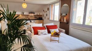 a bedroom with a large white bed with red pillows at Duplex 4pers Calme Parking - Proche Gare & Rocade in Fleury-les-Aubrais