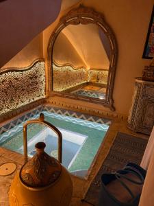 a bathroom with a large mirror and a pool of water at Riad Jamaique - Marrakech in Marrakesh