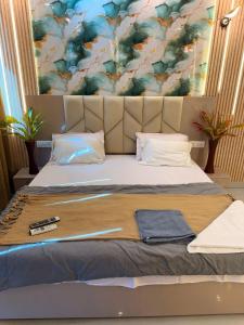 a bed with a headboard with a remote control on it at Luxury Jacuzzi Studio -Couple Friendly- Noida in Ghaziabad