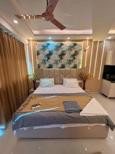 a bedroom with a large bed with a painting on the wall at Luxury Jacuzzi Studio -Couple Friendly- Noida in Ghaziabad