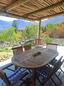 a wooden table and chairs on a patio at Stonehedge Cottages in Franschhoek