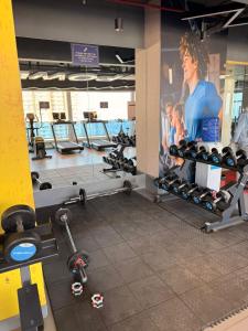 a gym with several tread machines and a large poster at Luxury Jacuzzi Studio -Couple Friendly- Noida in Ghaziabad