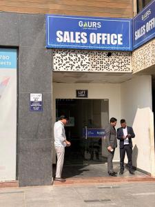 three men are standing outside of a sales office at Luxury Jacuzzi Studio -Couple Friendly- Noida in Ghaziabad