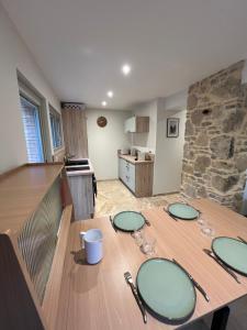 a wooden table with four plates on it in a kitchen at Chez Armand in Le Plan-de-la-Tour