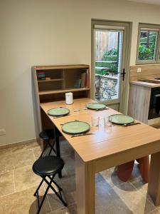 a wooden table with green plates on it in a kitchen at Chez Armand in Le Plan-de-la-Tour +9 photos