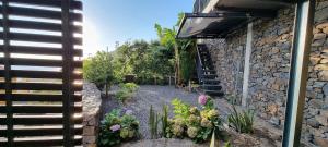 a garden with flowers and plants next to a building at Villa Palace Fernandes with Jacuzzi in Calheta