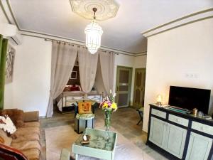 a living room with a couch and a tv at Dar HISANE in Marrakesh