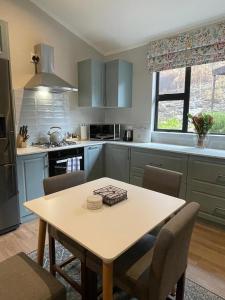 a kitchen with a table and chairs in a kitchen at Stonehedge Cottages in Franschhoek +11 photos