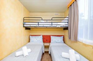 a small room with two beds and a window at Arena Tasalera Mobile Homes in Premantura