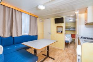 a small room with a table and a kitchen at Arena Tasalera Mobile Homes in Premantura
