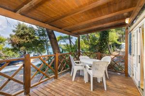 a wooden deck with a table and chairs on it at Arena Tasalera Mobile Homes in Premantura