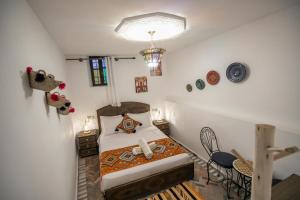 a small bedroom with a bed and a table and chairs at Guest House Jnan Sbil in Fez